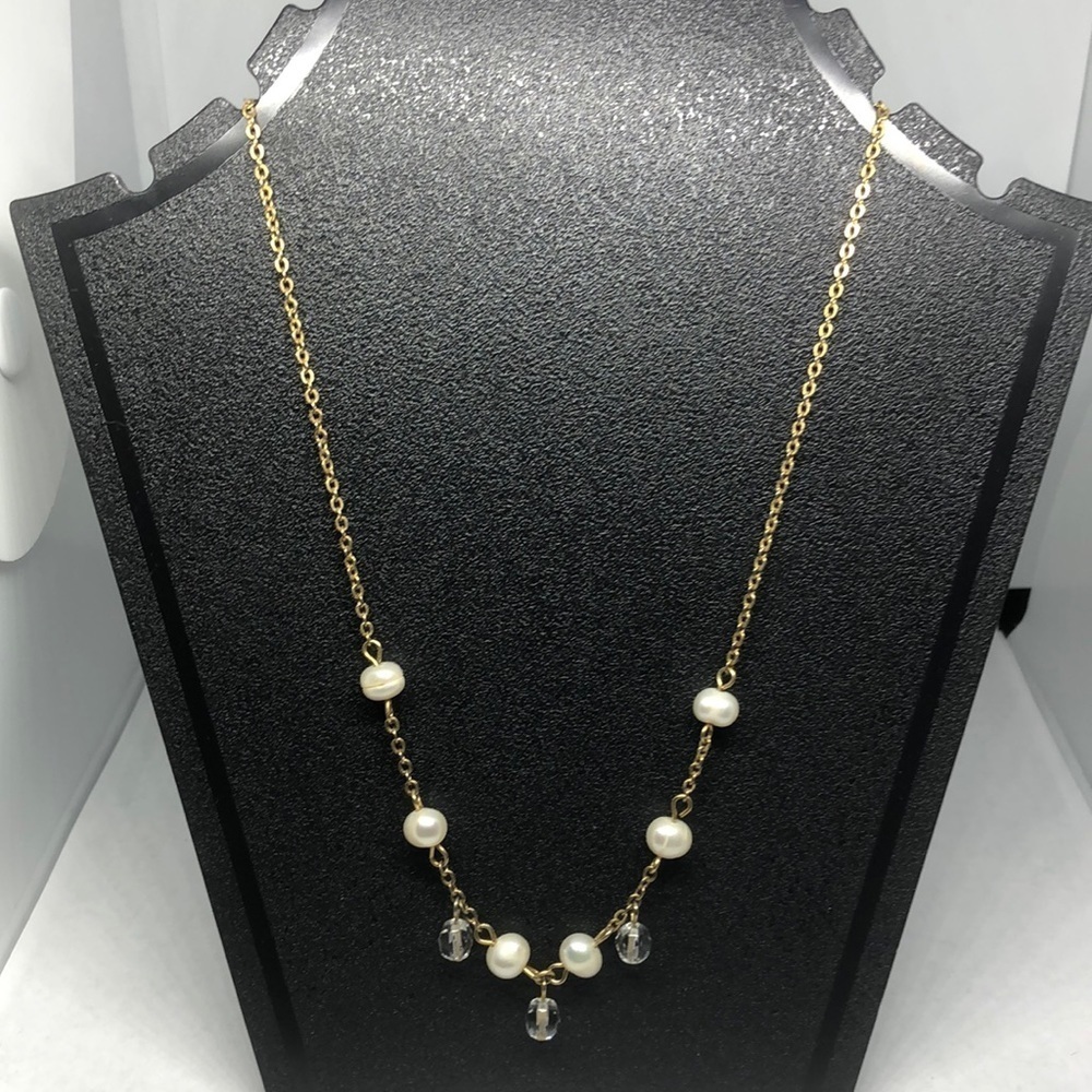 Cultured freshwater pearl and crystal necklace on a gold tone chain.